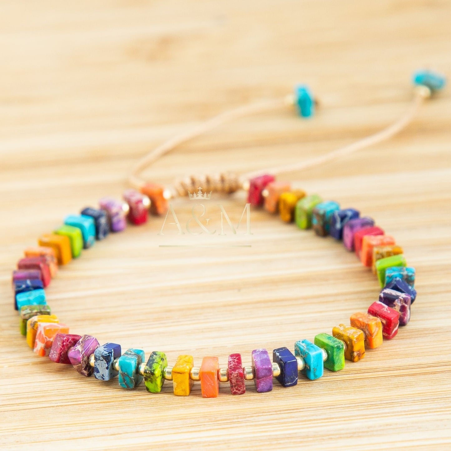 Handmade rainbow beaded bracelet with colorful square beads and gold spacers on adjustable cord – vibrant unisex jewelry accessory