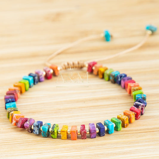 Handmade rainbow beaded bracelet with colorful square beads and gold spacers on adjustable cord – vibrant unisex jewelry accessory