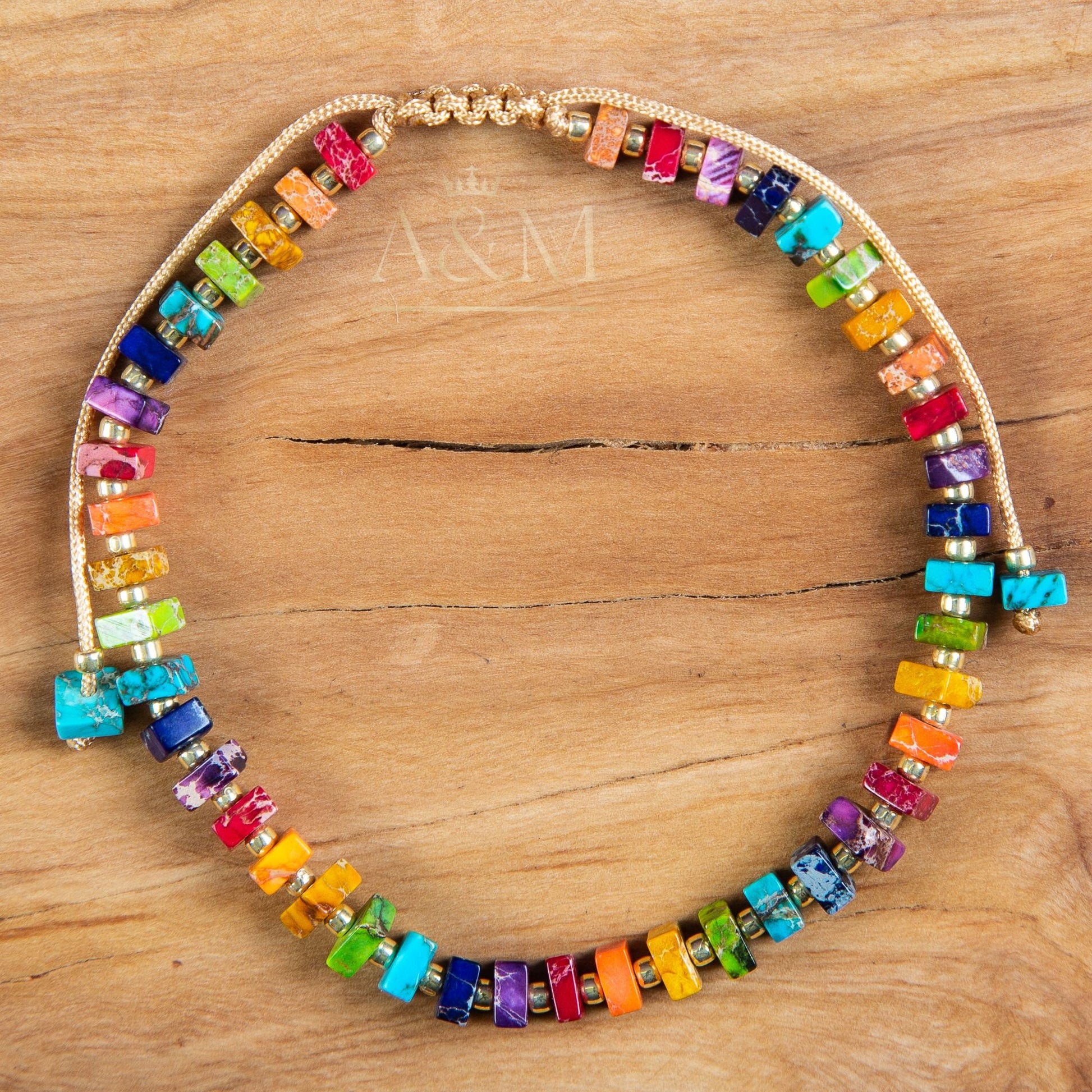 Handmade rainbow beaded bracelet with colorful square beads and gold spacers on adjustable cord – vibrant unisex jewelry accessory